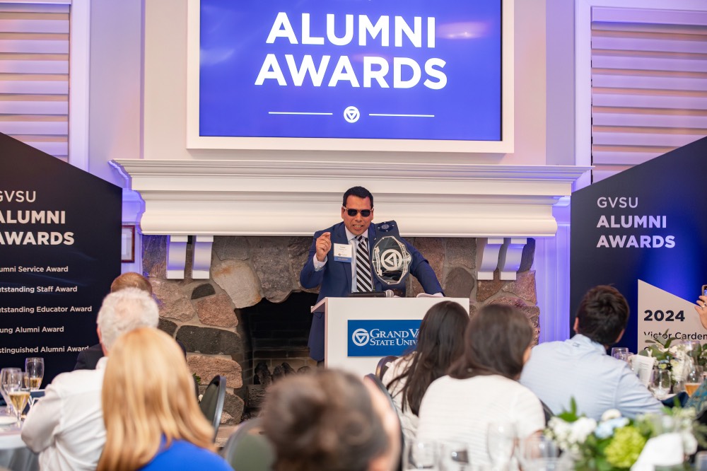 Victor Cardenas pointing to crowd with sunglasses on